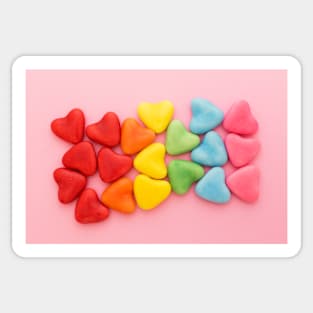 Heart-shaped multi-colored candy ordered in rainbow colors and shape on a pink background Sticker